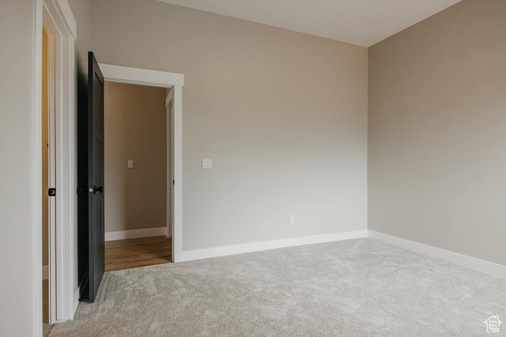 Empty room with carpet floors and baseboards
