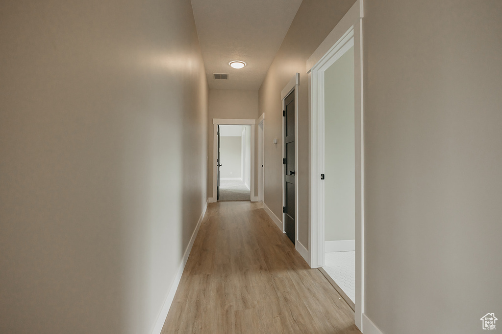 Hallway featuring light wood-style flooring and baseboards
