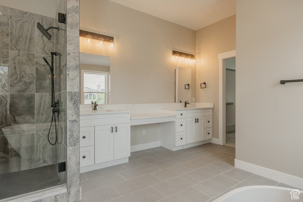 Full bathroom with a shower stall, double vanity, tile patterned flooring, and a tub