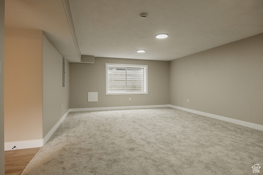 Spare room with baseboards, a smoke detector, and carpet flooring
