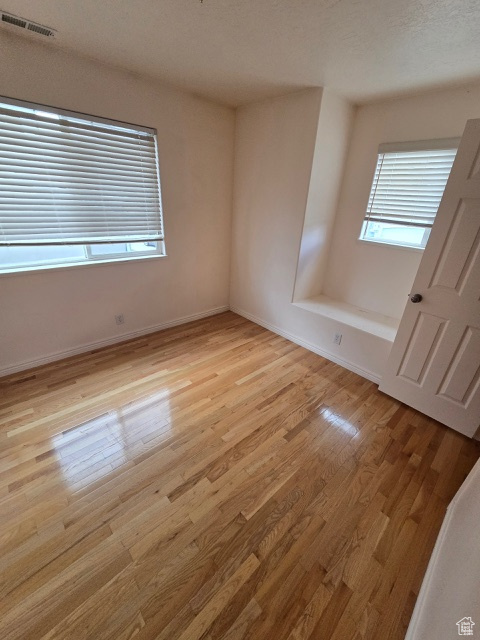 Spare room featuring light wood-type flooring and baseboards