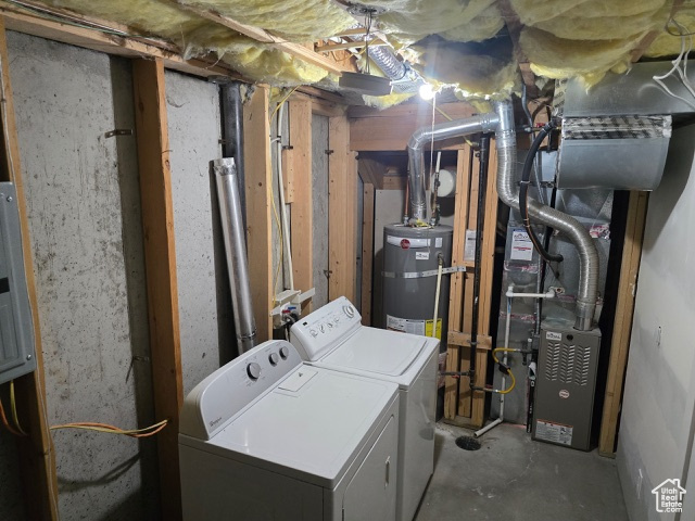 Unfinished basement featuring washer and clothes dryer and water heater