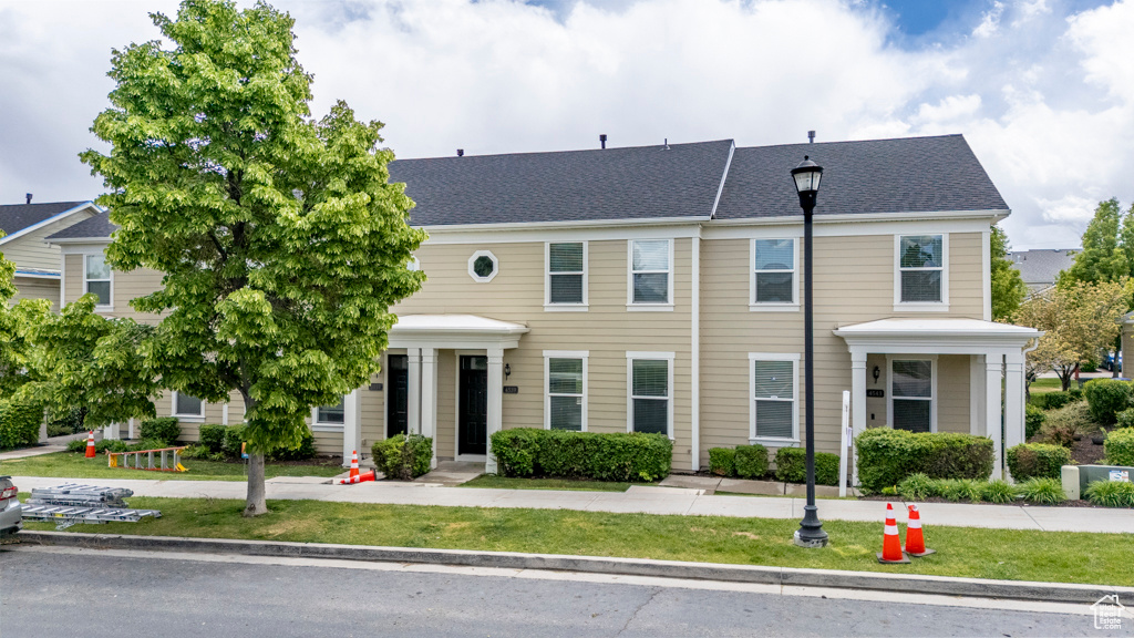 Townhome / multi-family property featuring a front yard