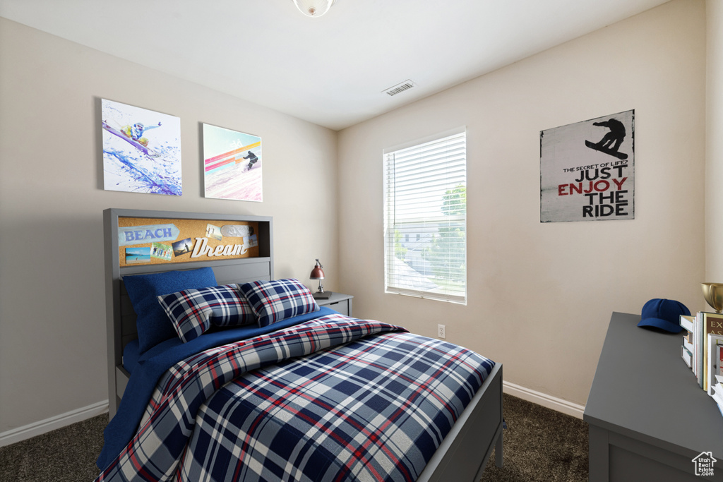 Bedroom with dark carpet and baseboards