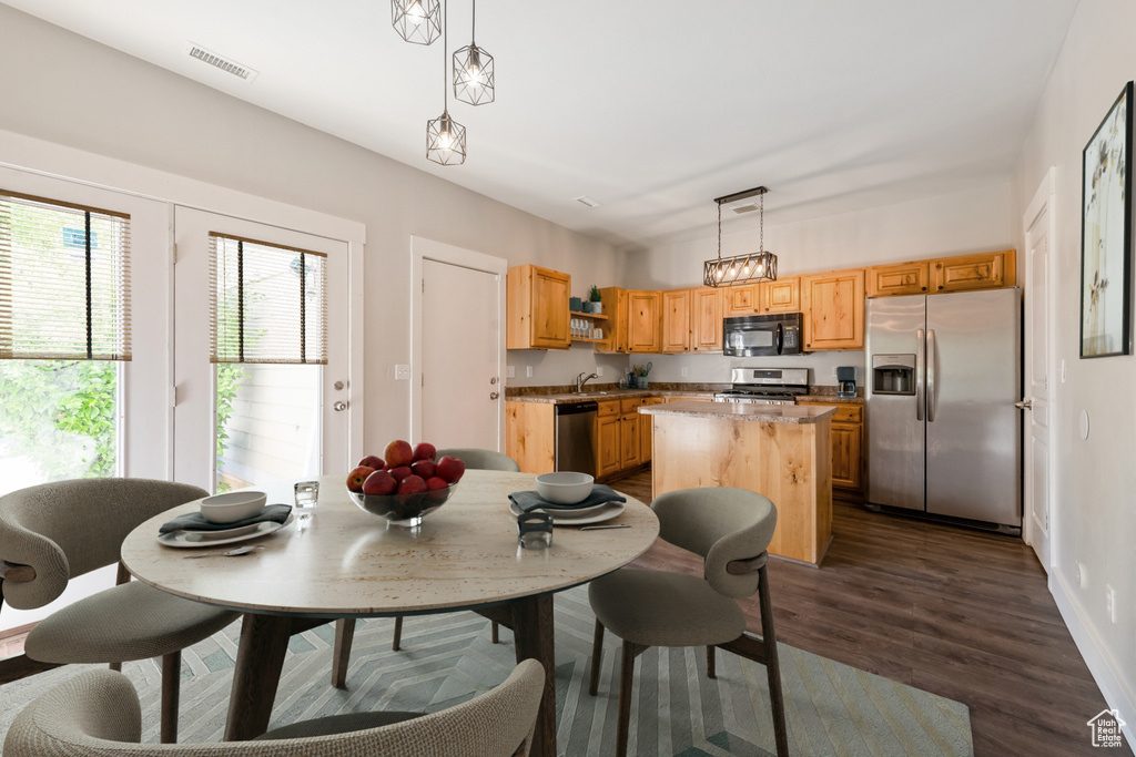 Dining space with dark wood-style flooring and baseboards