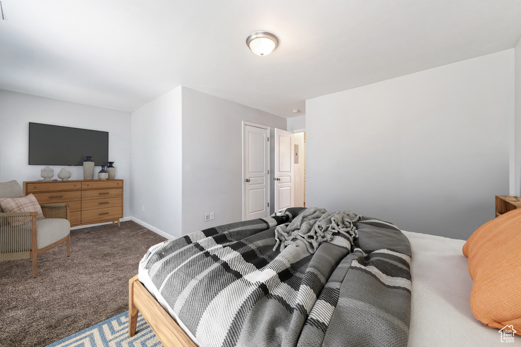 Bedroom featuring carpet and baseboards