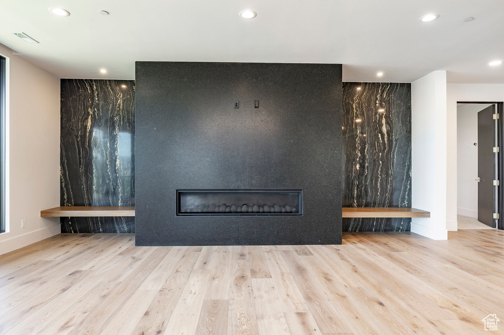 Unfurnished living room featuring a large fireplace, wood finished floors, and recessed lighting