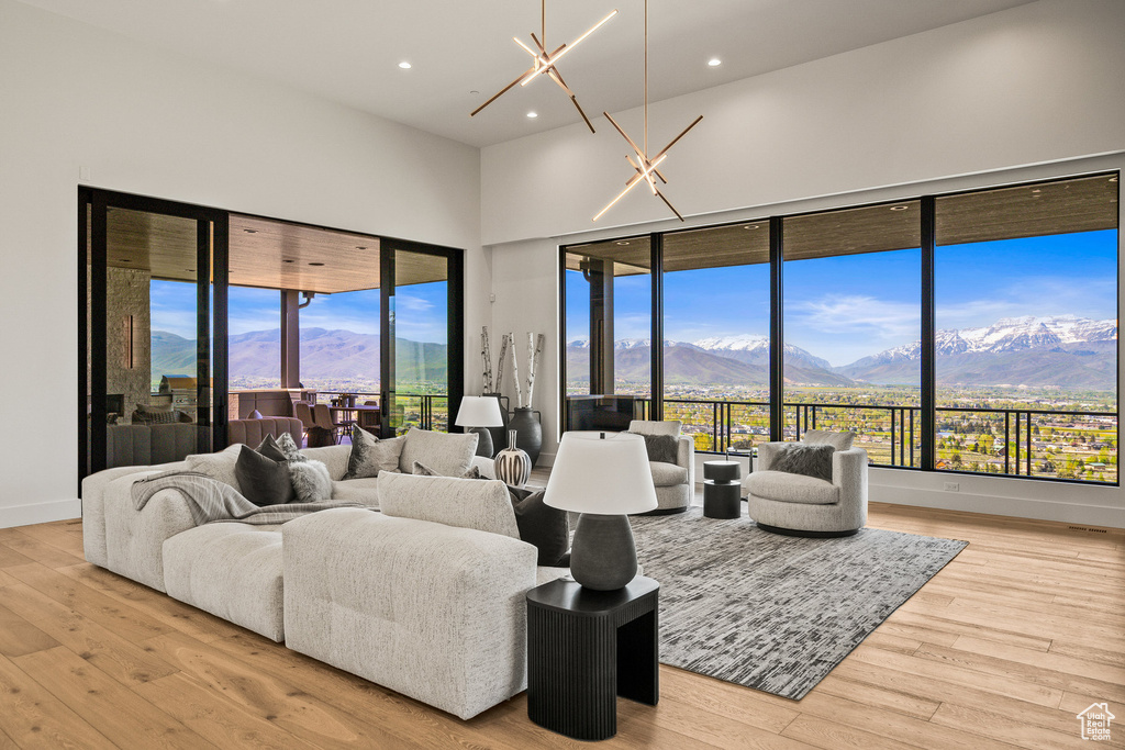 Living room with a mountain view, recessed lighting, light wood finished floors, a high ceiling, and baseboards