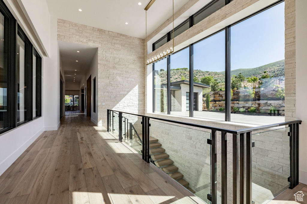 Corridor featuring a high ceiling, recessed lighting, a mountain view, and wood-type flooring