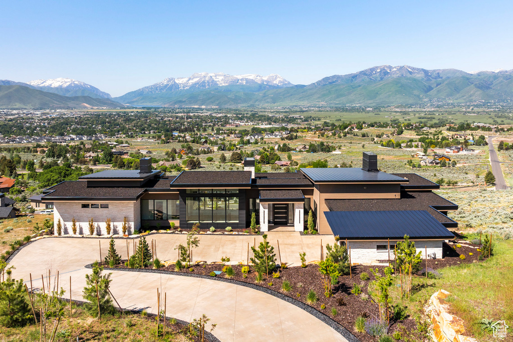 View of front of property featuring a chimney, a mountain view, and curved driveway