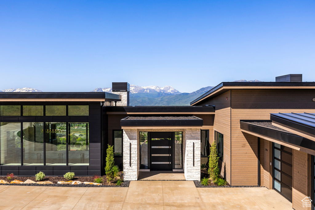 View of exterior entry featuring a mountain view and stone siding