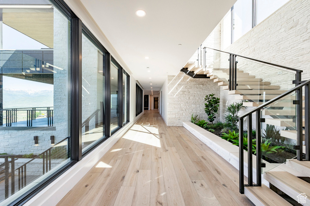 Hallway featuring hardwood / wood-style floors, stairway, and recessed lighting