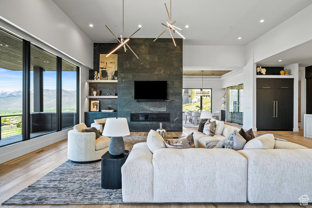 Living room with plenty of natural light, recessed lighting, wood finished floors, and a high end fireplace