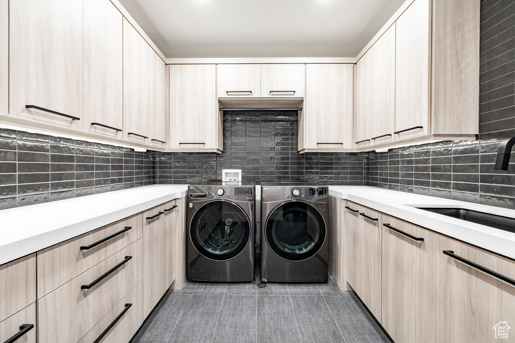 Laundry area with cabinet space, light tile patterned floors, and independent washer and dryer