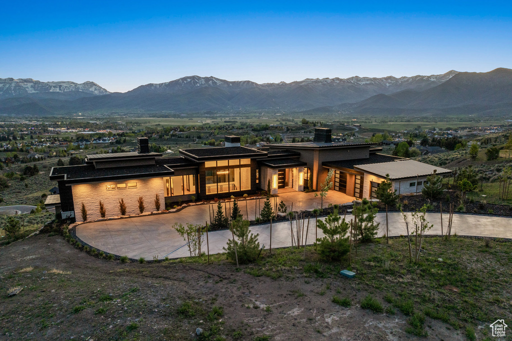Rear view of property with a chimney, a mountain view, and driveway