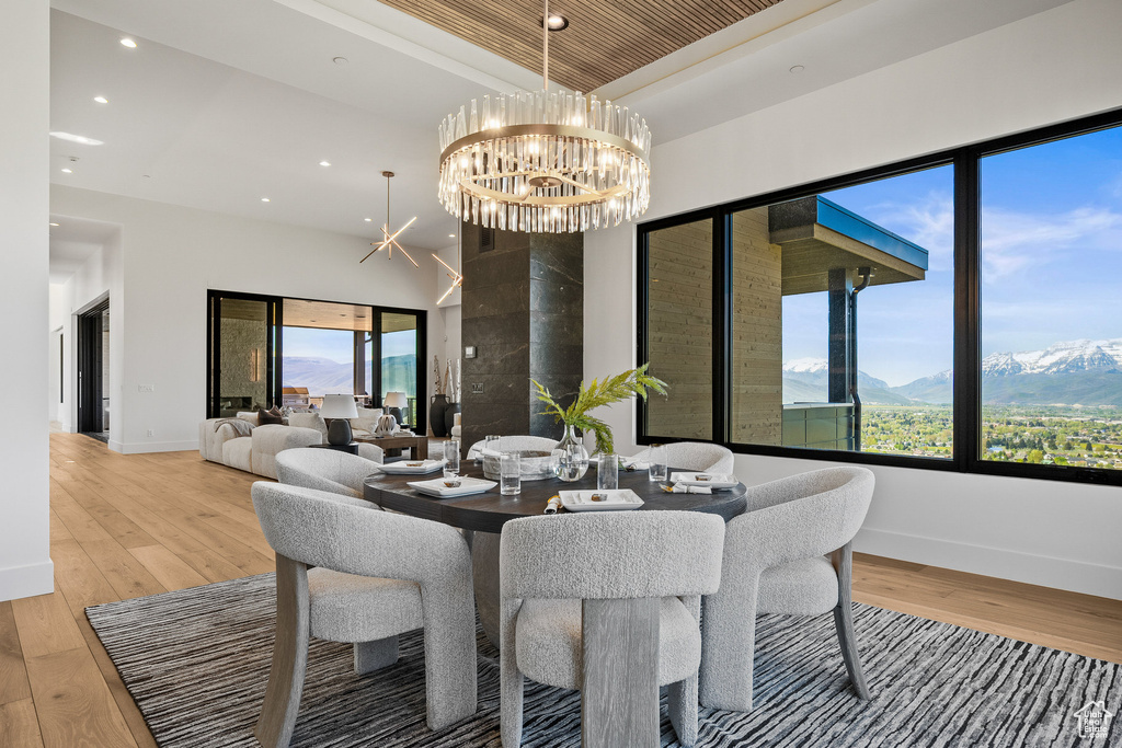 Dining room featuring light wood-type flooring, recessed lighting, plenty of natural light, a chandelier, and baseboards