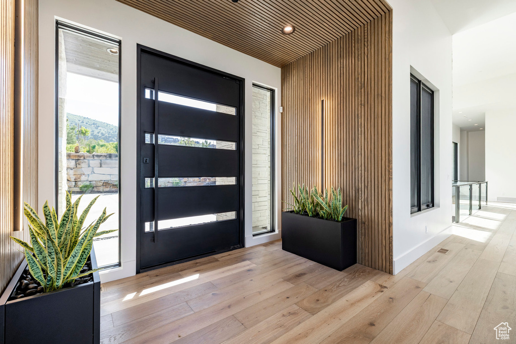 Foyer entrance with light wood finished floors and recessed lighting