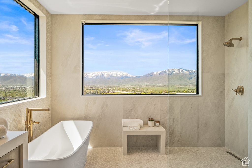 Full bath with a mountain view, a freestanding tub, and tiled shower