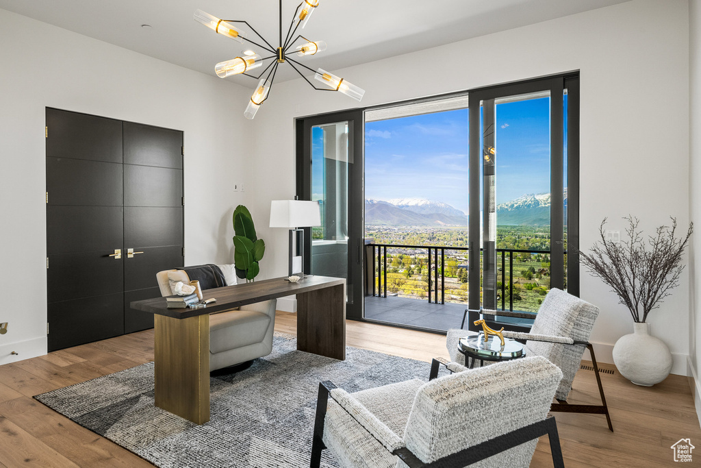 Office area featuring wood finished floors, a chandelier, and a mountain view