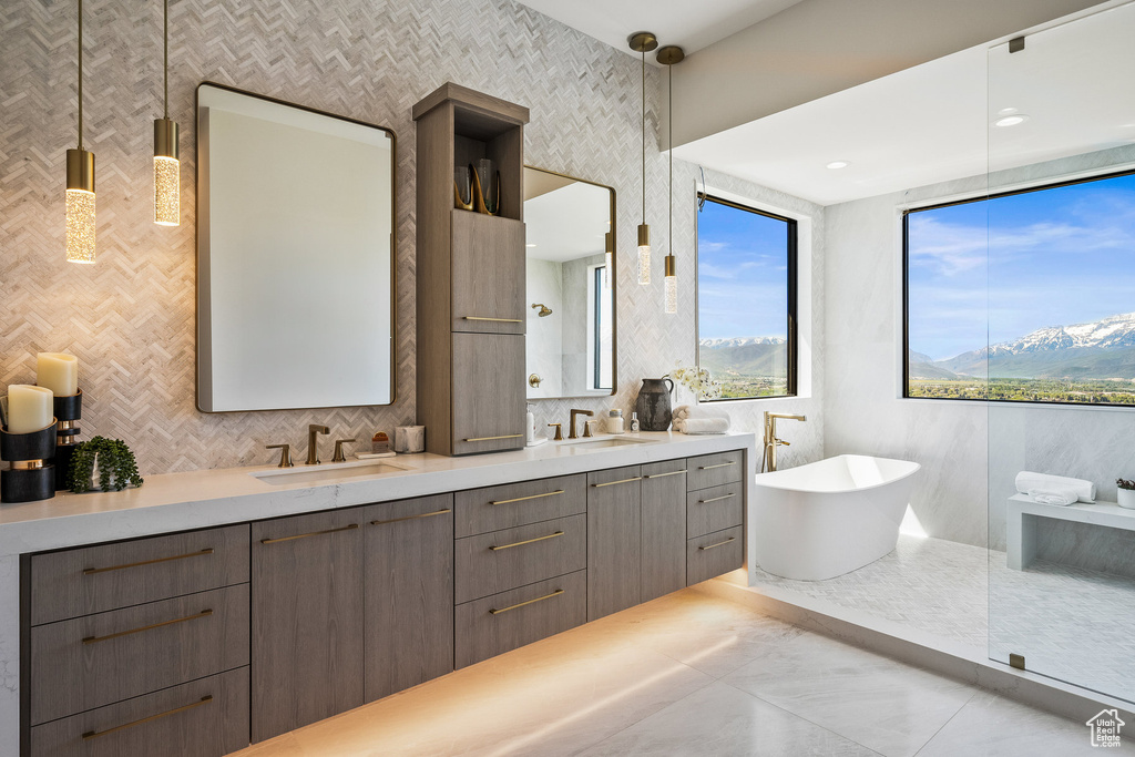 Full bathroom featuring a freestanding bath, double vanity, and tasteful backsplash