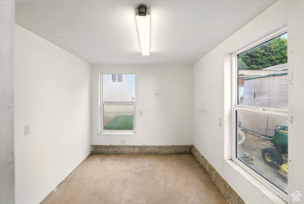 Unfurnished room with unfinished concrete flooring