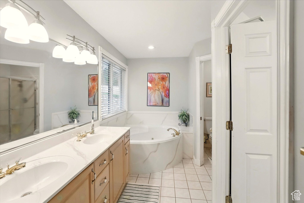 Full bathroom with toilet, a bath, tile patterned floors, a shower stall, and double vanity