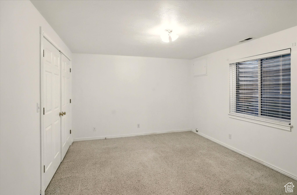 Unfurnished bedroom featuring baseboards, light colored carpet, and a closet