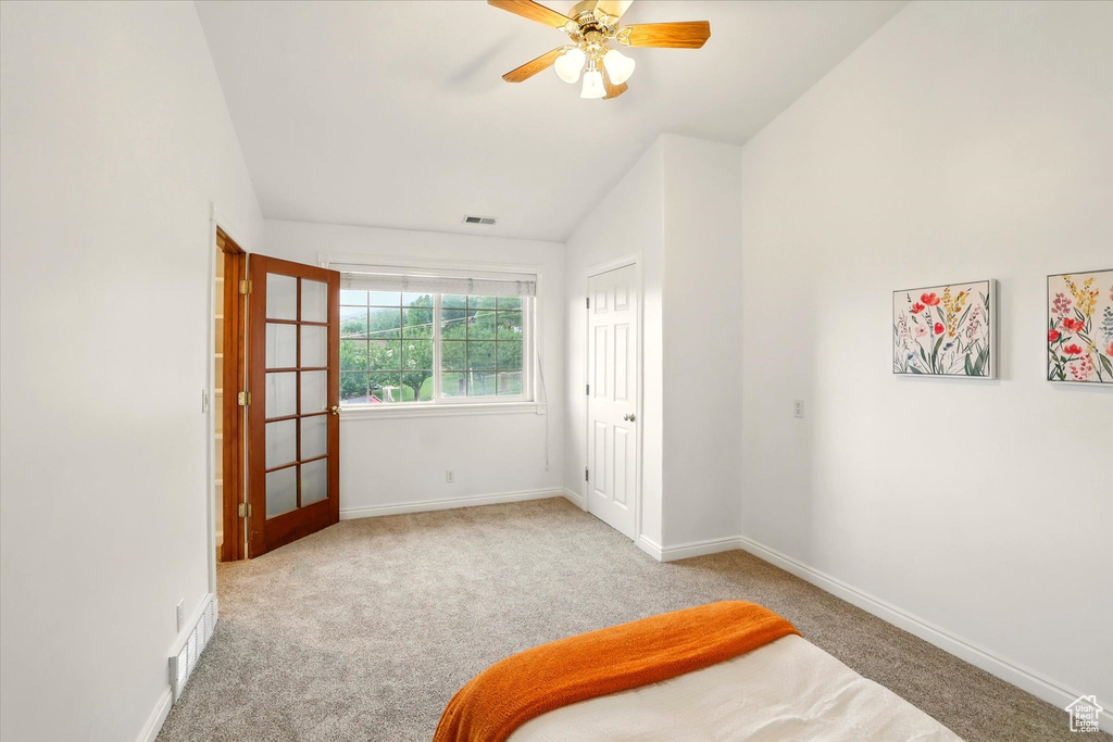 Unfurnished bedroom featuring carpet flooring, baseboards, a ceiling fan, and vaulted ceiling