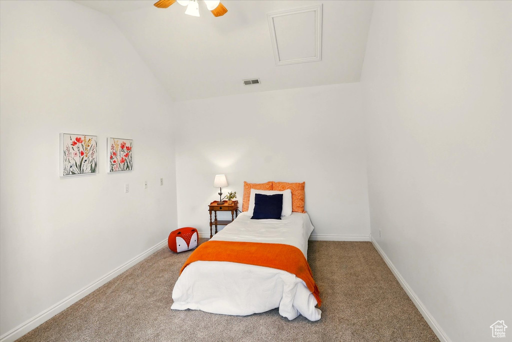 Carpeted bedroom with lofted ceiling, attic access, baseboards, and ceiling fan