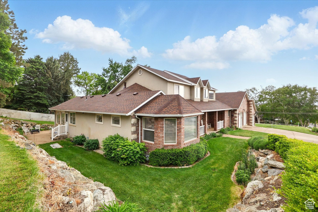 View of property exterior featuring stucco siding, a yard, concrete driveway, and a shingled roof
