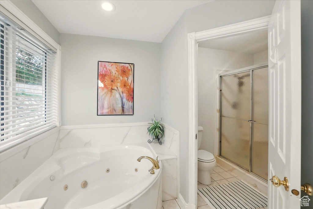 Bathroom with a shower stall, tile patterned flooring, a tub with jets, and toilet