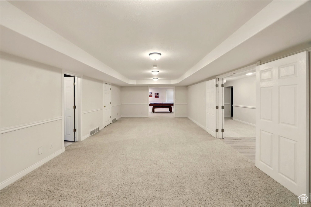 Finished basement featuring light colored carpet and baseboards