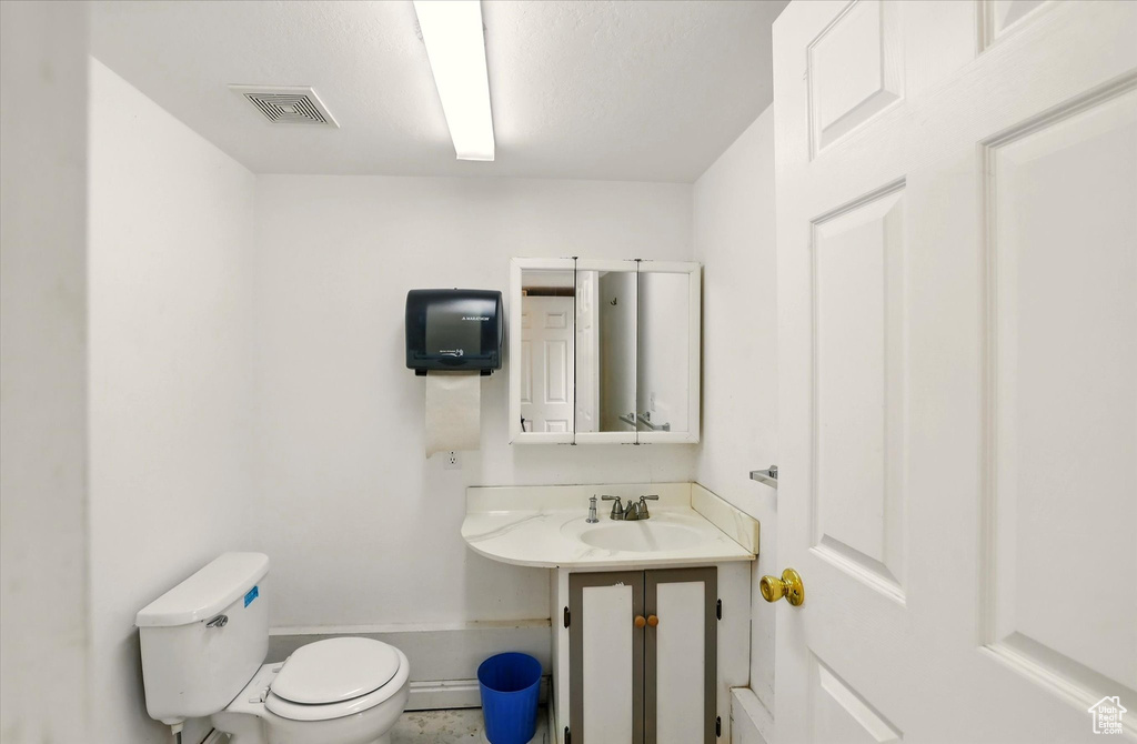 Bathroom featuring a sink, toilet, and baseboards