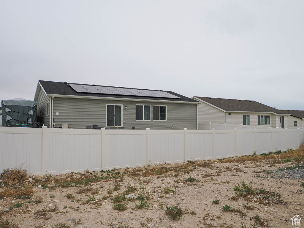 View of home's exterior with solar panels and fence