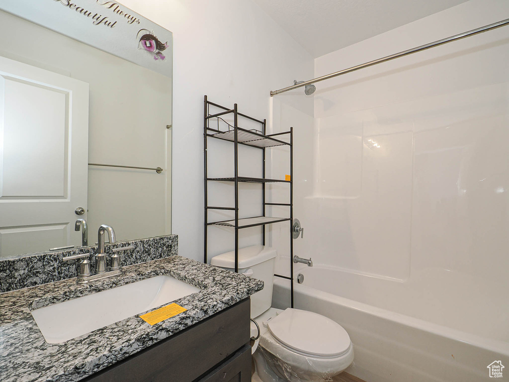 Bathroom featuring toilet, bathtub / shower combination, and vanity