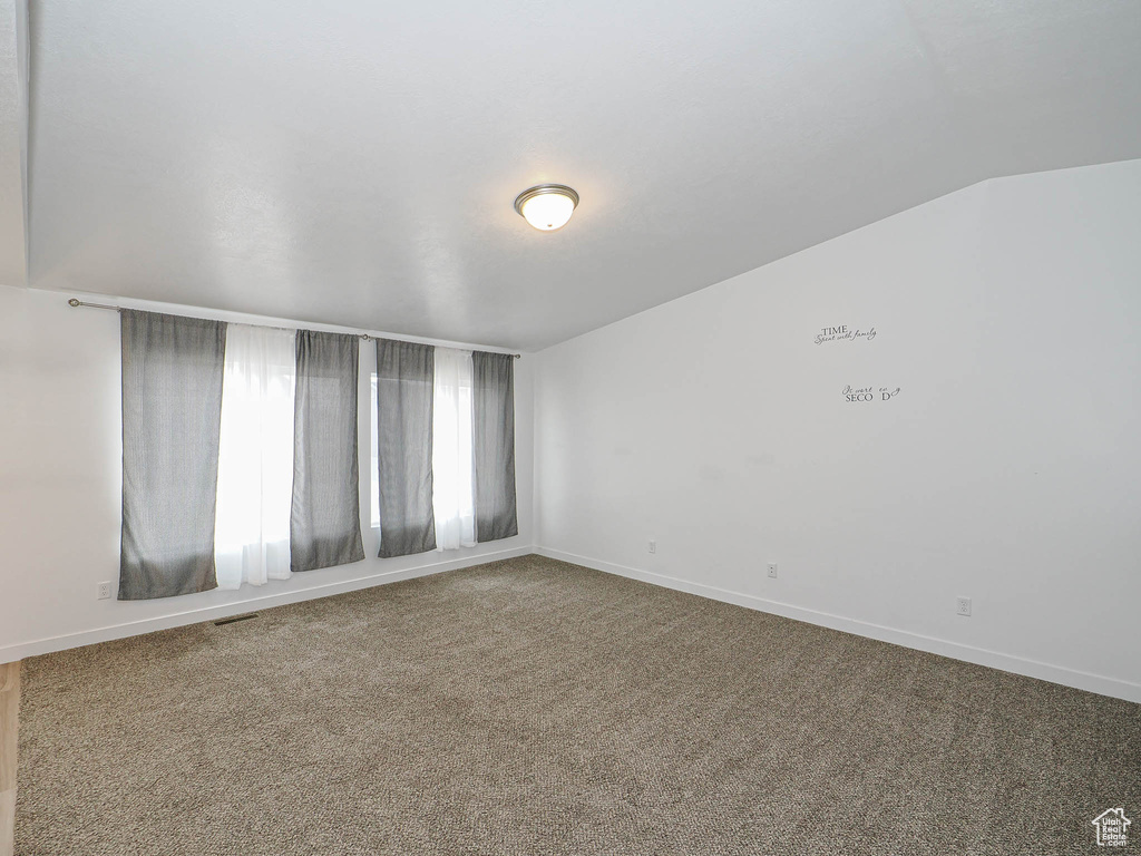 Empty room featuring carpet flooring and baseboards