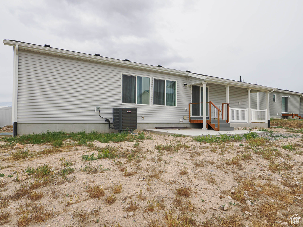 Rear view of house featuring central AC unit and a porch