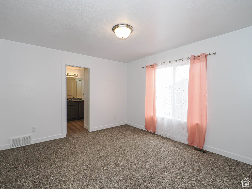 Spare room with carpet and baseboards