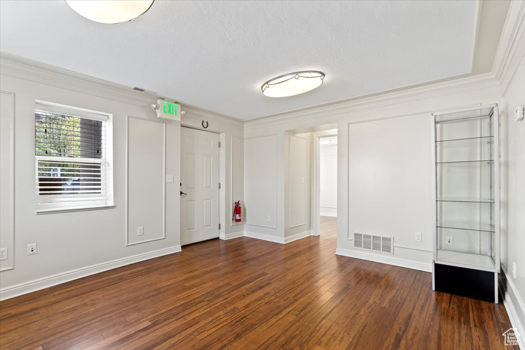 Foyer featuring crown molding, wood-type flooring, and baseboards