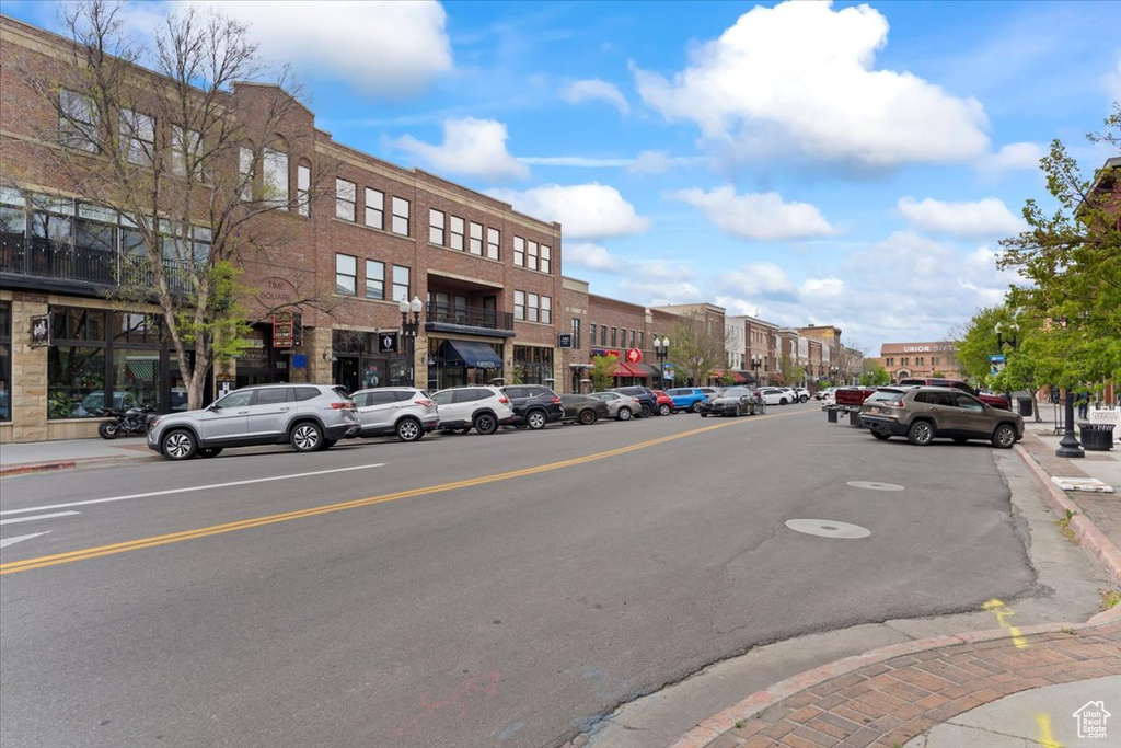 View of asphalt street with street lighting, sidewalks, and curbs