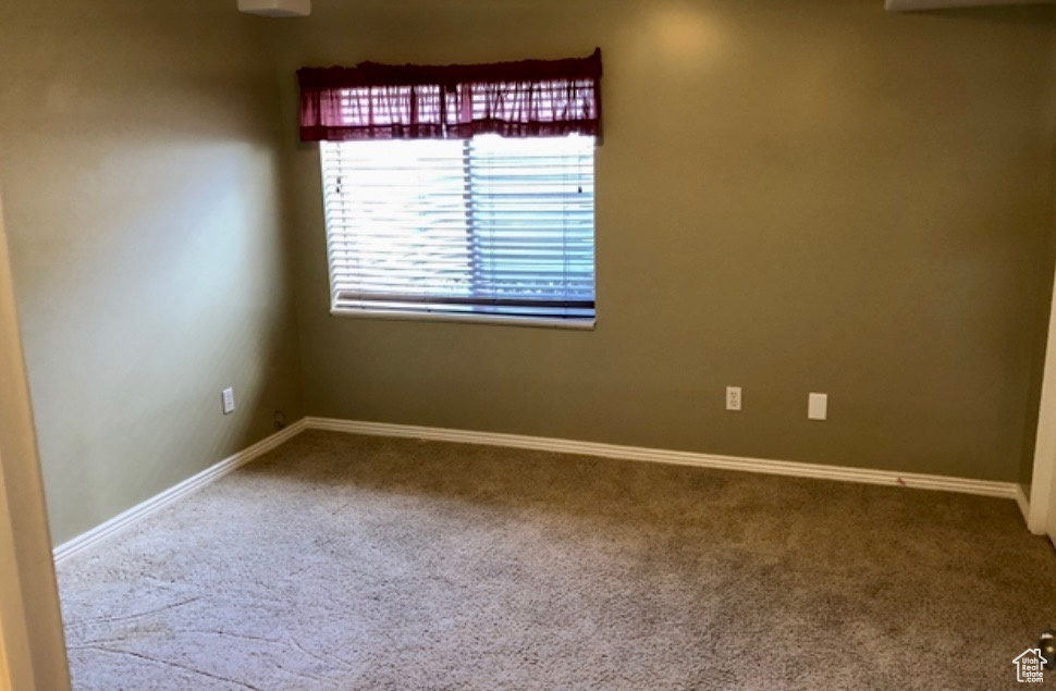 Spare room featuring carpet floors and baseboards