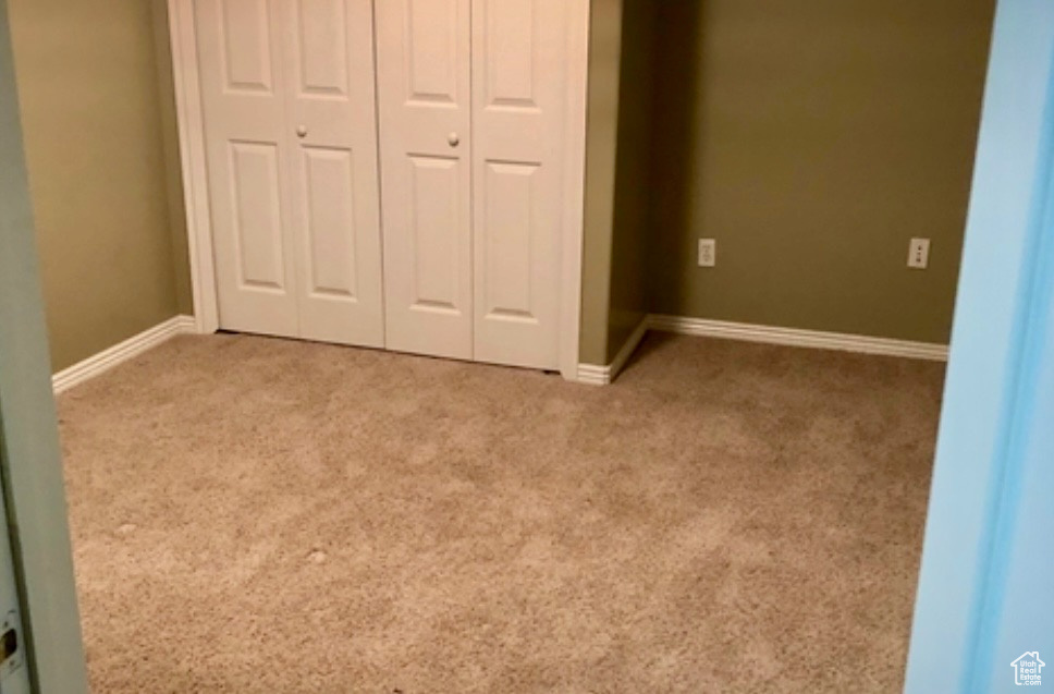 Unfurnished bedroom featuring carpet floors, a closet, and baseboards