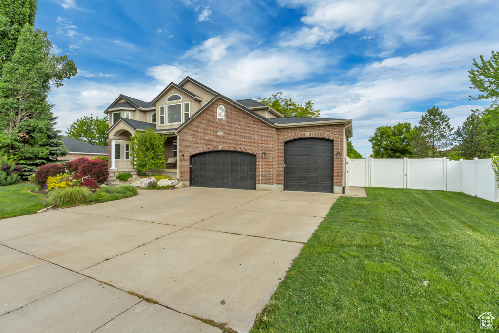 View of front of home featuring brick siding, a garage, concrete driveway, and a gate