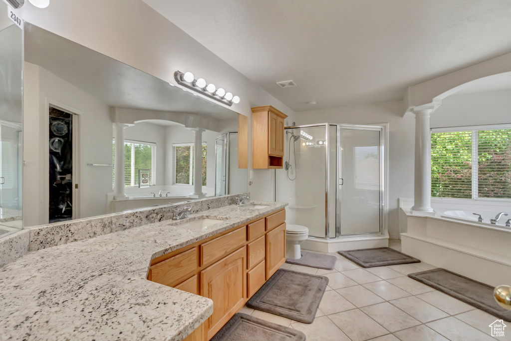 Bathroom with ornate columns, a stall shower, tile patterned floors, and plenty of natural light