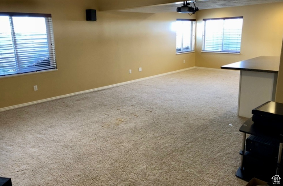 Carpeted spare room featuring baseboards