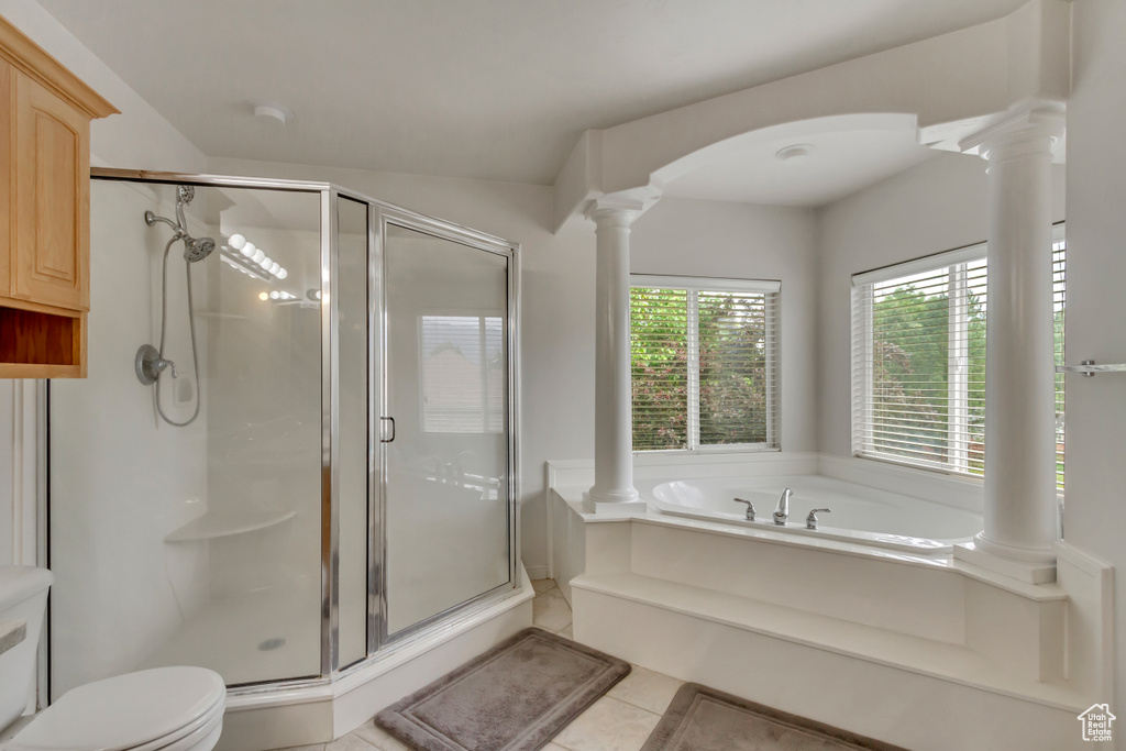 Full bath with decorative columns, a shower stall, a bath, and toilet