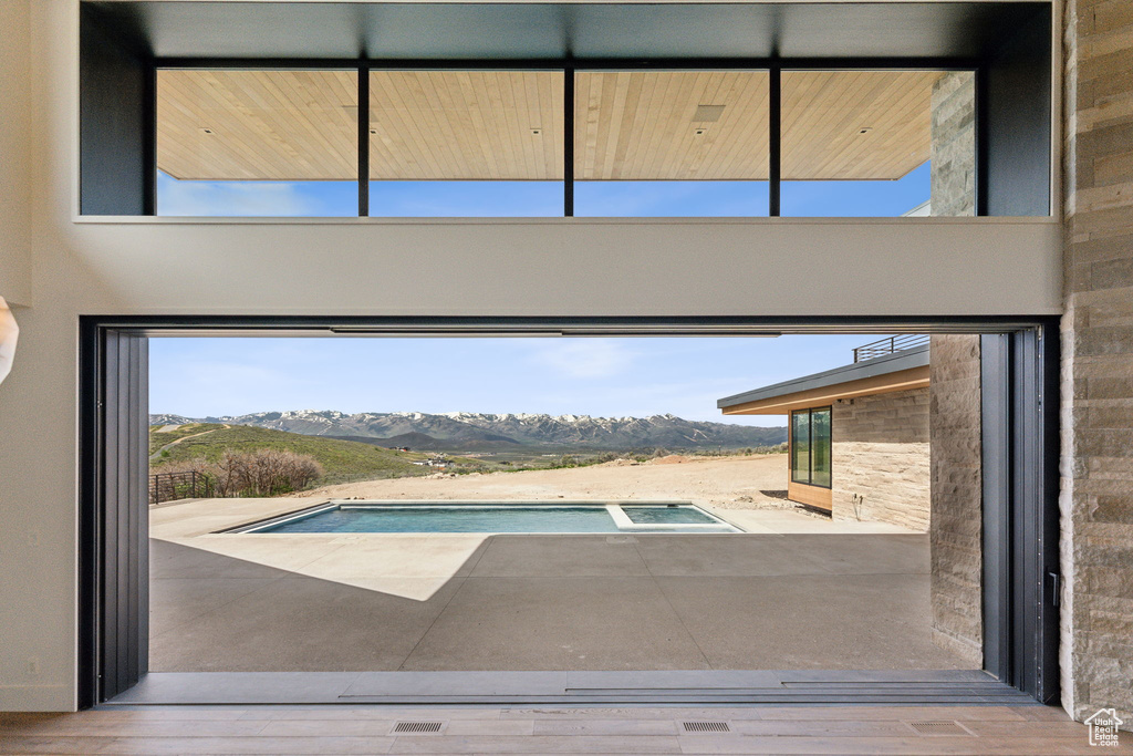 View of pool with a mountain view and a pool with connected hot tub