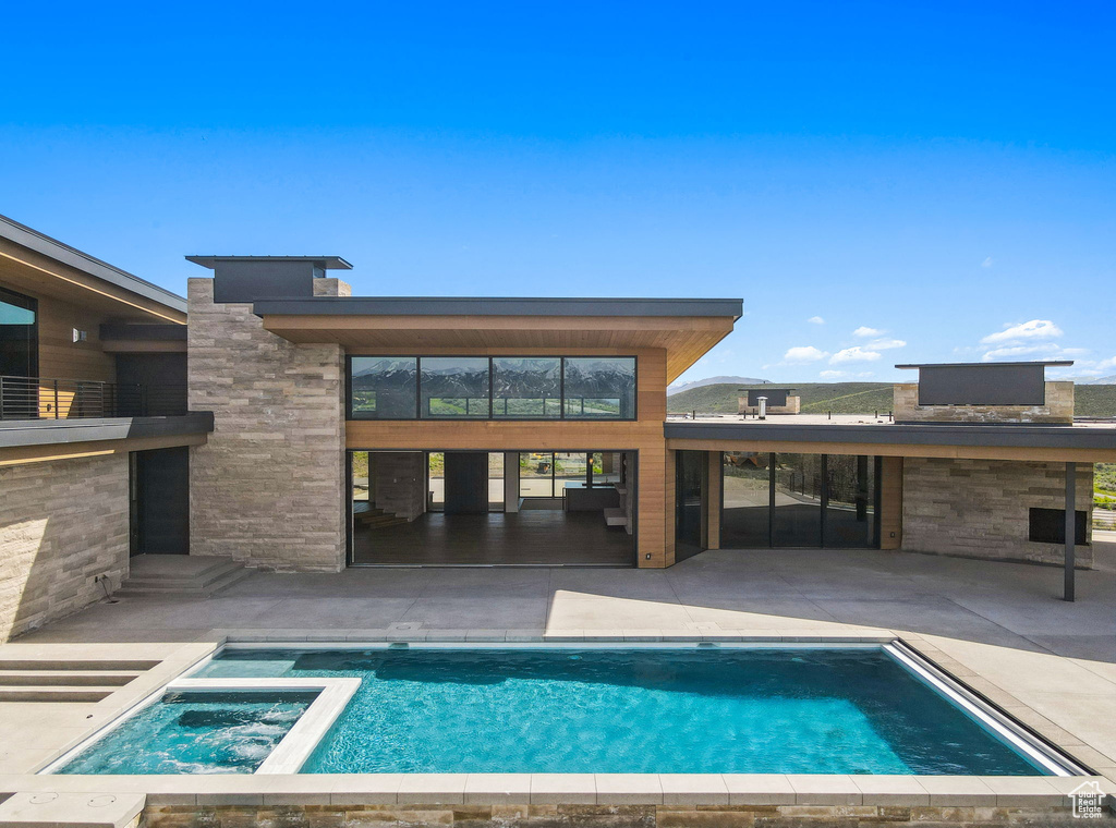 View of swimming pool with a patio area and a pool with connected hot tub