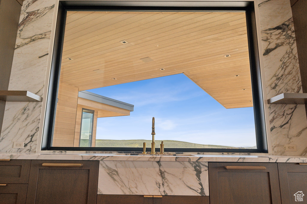 Kitchen view of a sink, light countertops, a mountain view, and dark brown cabinets