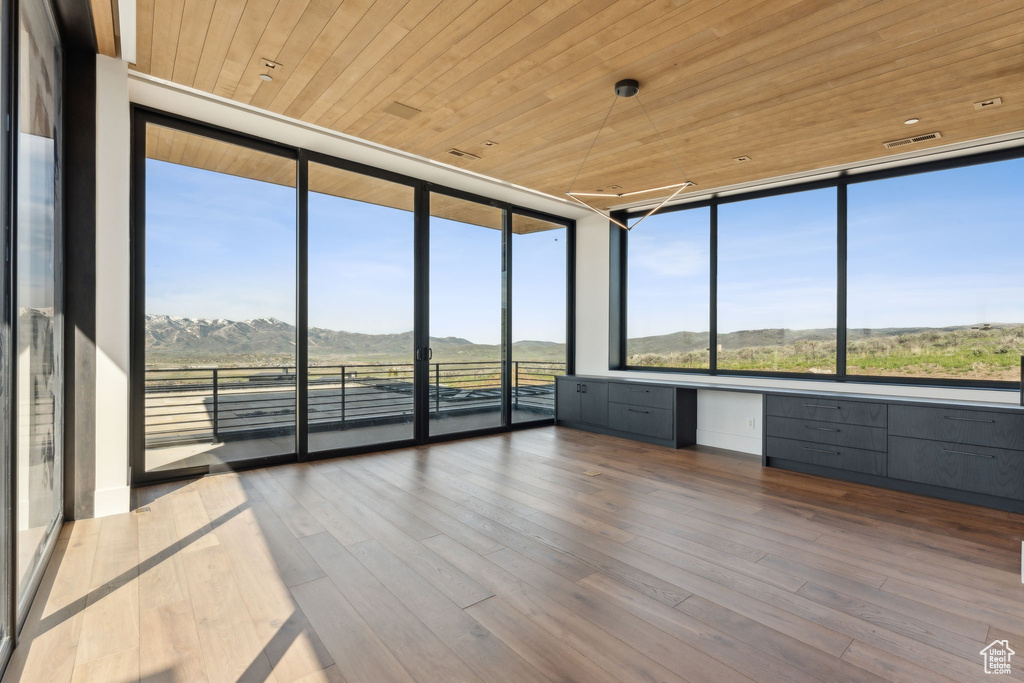 Unfurnished sunroom featuring built in desk and a mountain view